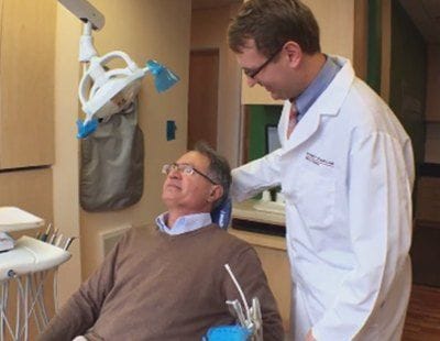 Dentist smiling at dental patient in exam chair