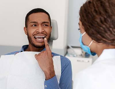 Patient pointing to his toothache in Frederick to his dentist