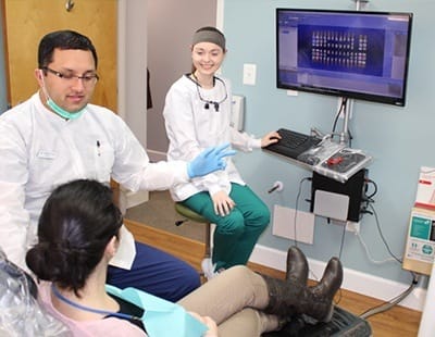 Dentist and team member talking to dental patients