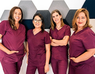 Four female dental team members smiling