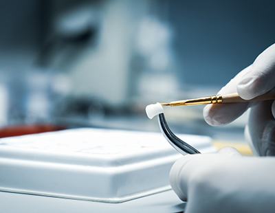 Gloved hands working on dental crown