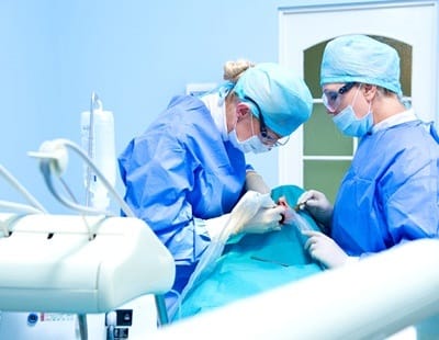 two dentists performing dental implant surgery 