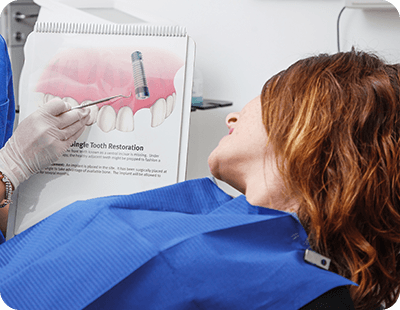 patient looking at a dental implant diagram 
