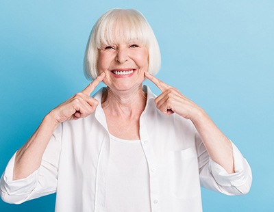 Woman pointing to her smile