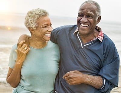 smiling couple taking a walk on a beach