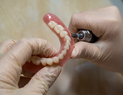 Lab technician shaping dentures