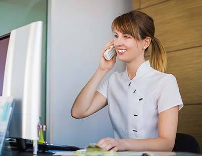 Receptionist discussing how to pay for dental emergencies in Frederick