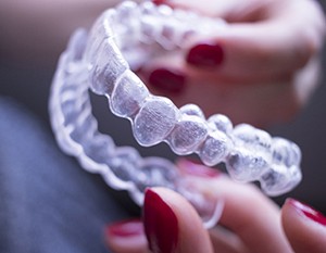 Person holding clear aligner from Invisalign in Frederick