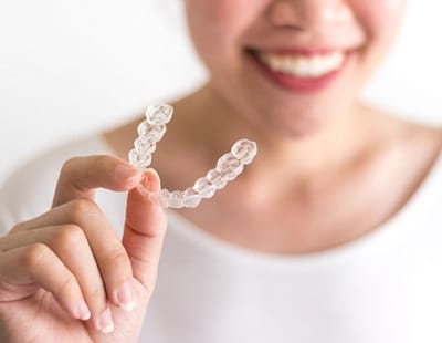 Someone holding up a clear aligner tray