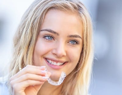 A young woman putting in an aligner