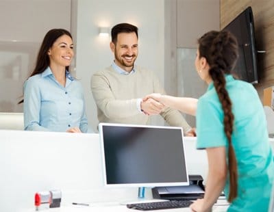 A couple shaking hands with the receptionist
