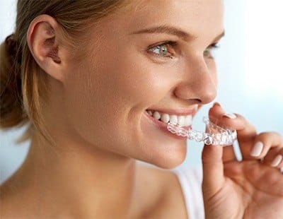 Woman placing Invisalign tray