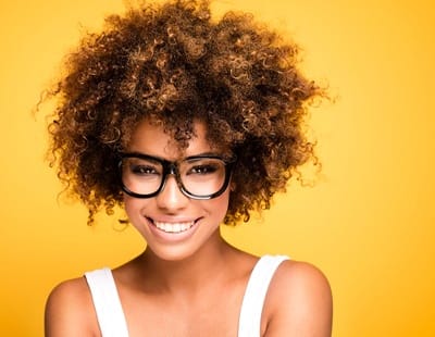 An up-close look at a woman using a whitening strip to brighten her smile at home