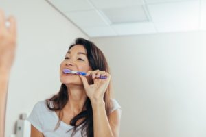 person brushing their teeth in their bathroom while self-isolating