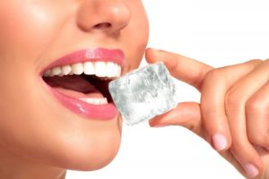 close up of person chewing ice and harming their dental implants in Frederick 