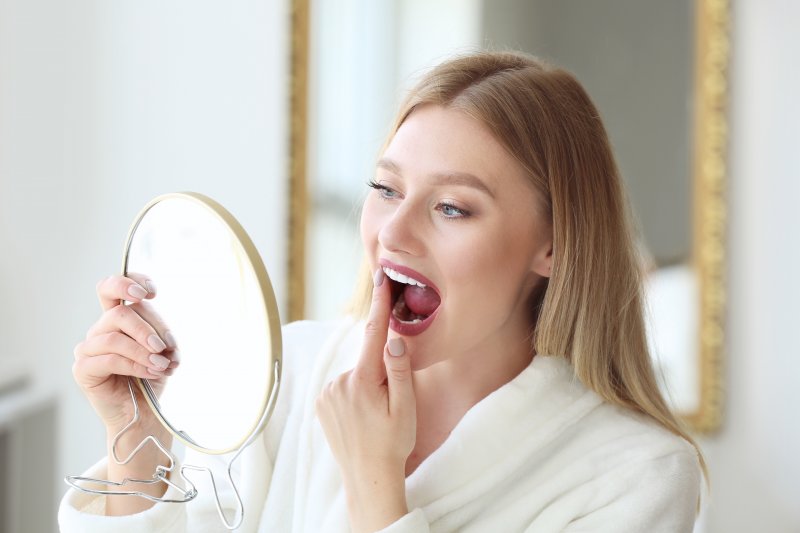 woman checking her dental implants in Frederick