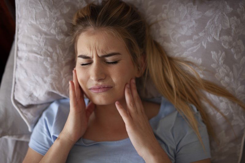 WOman in bed with tooth pain