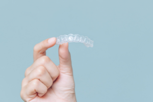 a closeup of a patient holding their Invisalign aligner