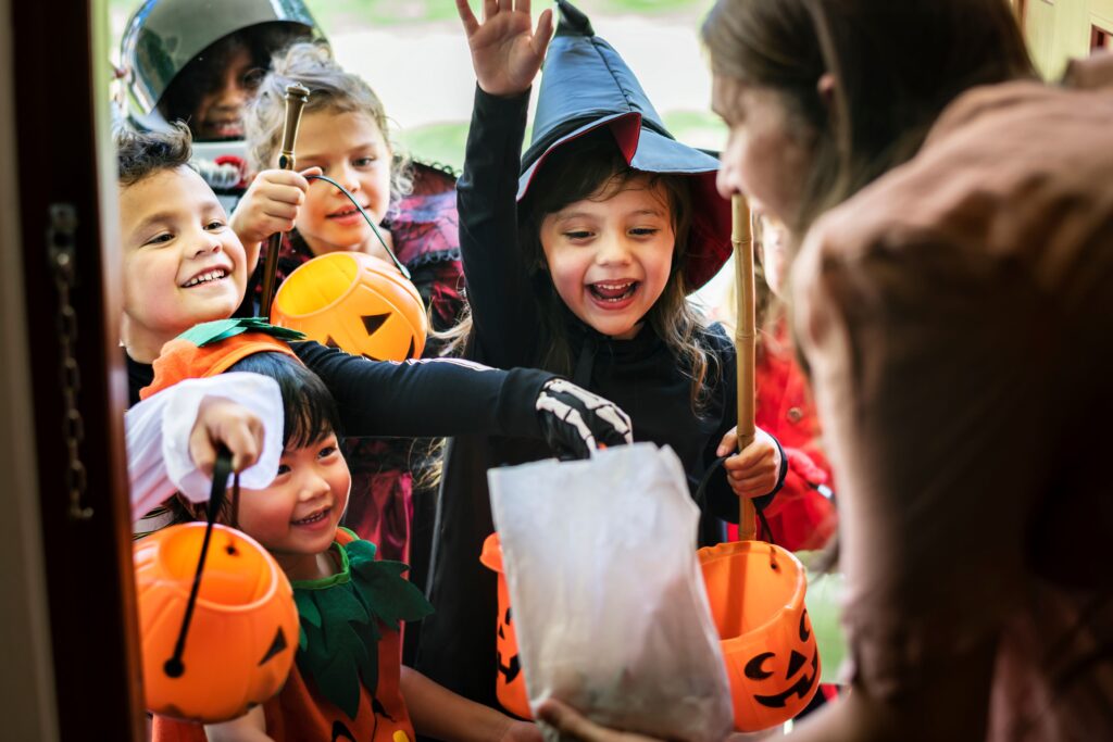 Kids in Halloween costumes at door trick-or-treating