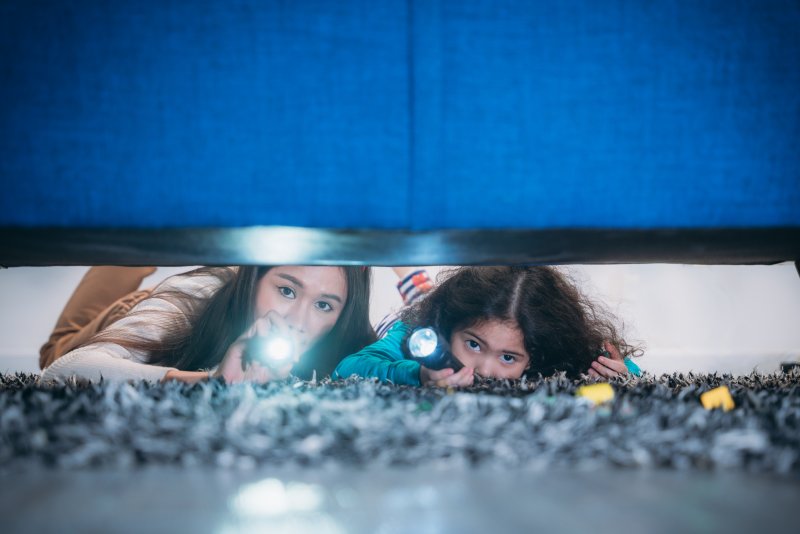 Patient looking for Invisalign aligner under couch with child